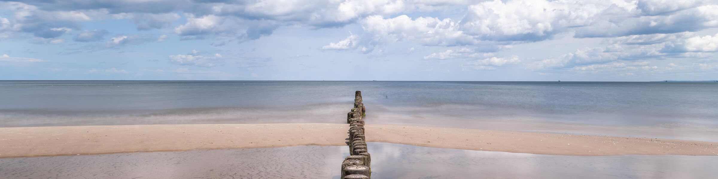 Strand mit Buhne im Wasser